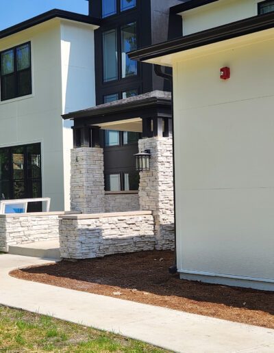 The exterior of a modern home with a stone walkway.