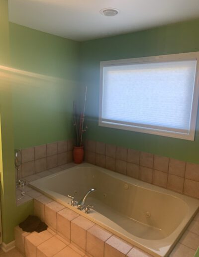 A bathroom with a tub and a window.