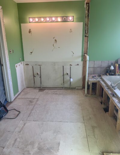 A bathroom being remodeled with green walls and a tub.