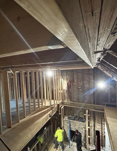 A man is standing in the attic of a building that is under construction.