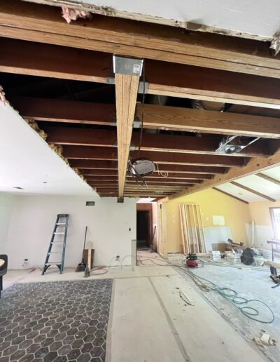 A room with wood beams and a ladder.