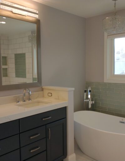 A bathroom with a tub, sink and window.