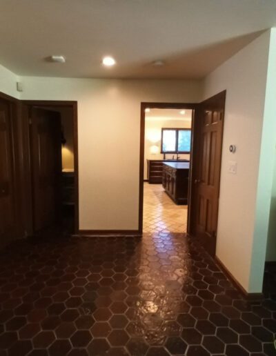 A room with a tile floor and wooden doors.