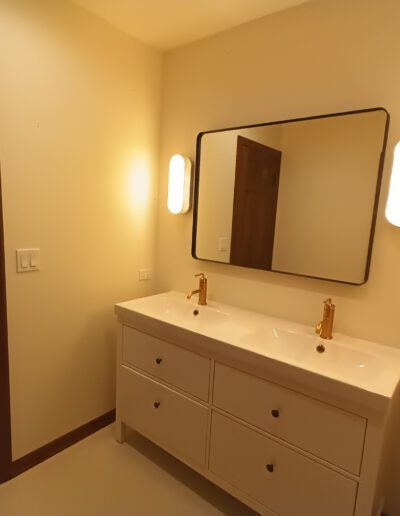 A bathroom with two sinks and a mirror.