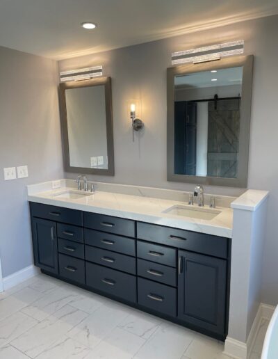 A bathroom with two sinks and a mirror.