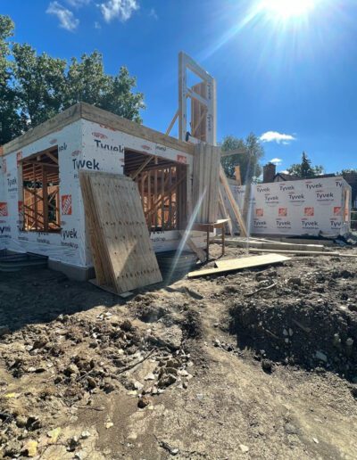 A house under construction with a sun shining on it.