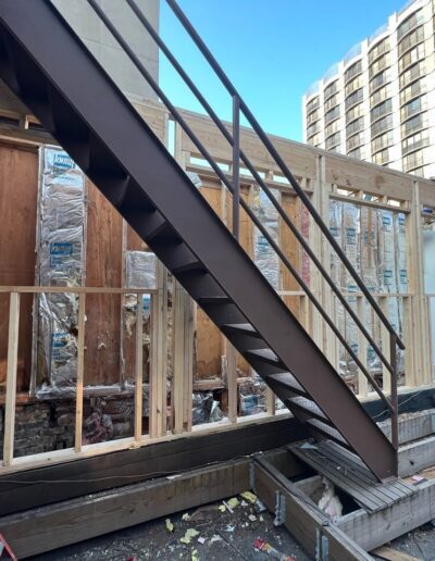 A building under construction with stairs and a ladder.