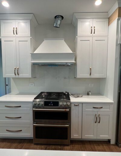 A kitchen with white cabinets and stainless steel appliances.