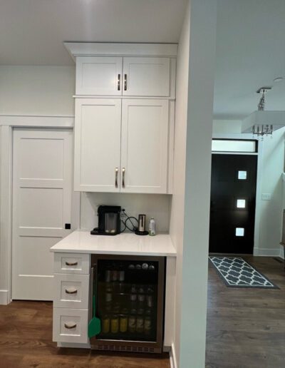 A small kitchen with a refrigerator and stairs.