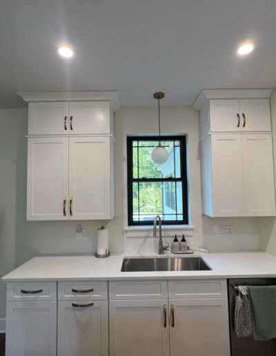 A kitchen with white cabinets and a sink.