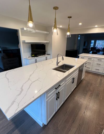 A kitchen with white marble counter tops and stainless steel appliances.