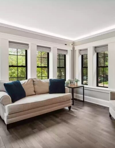 A living room with hardwood floors and large windows.