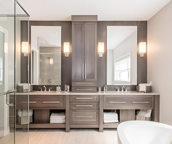 Modern bathroom with dual sinks, large mirrors, wooden cabinetry, and wall-mounted lights. A glass shower and a freestanding bathtub are visible.