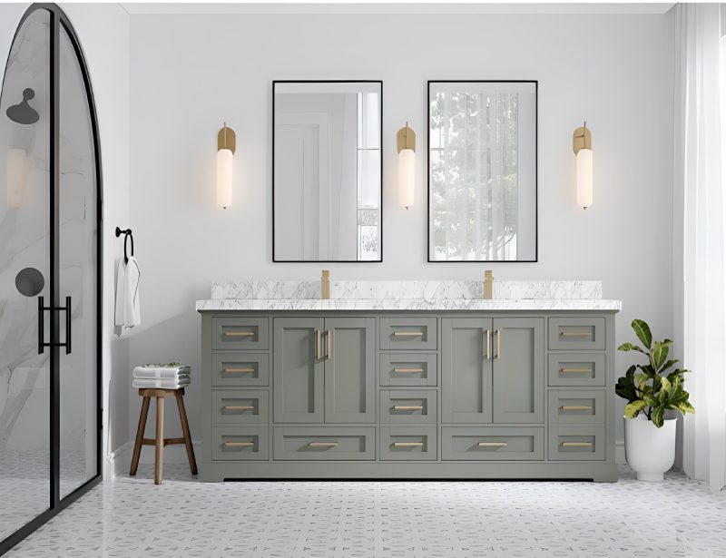 A modern bathroom with a green double vanity, two mirrors, wall sconces, a glass shower door, and a potted plant.